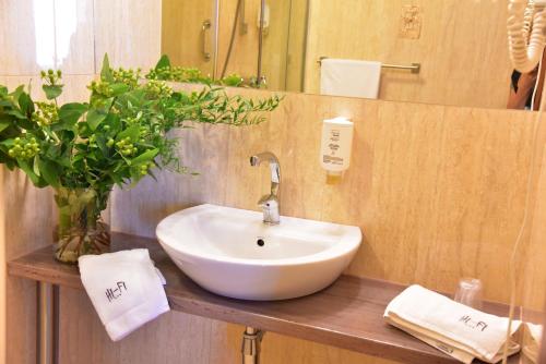 ein Badezimmer mit einem weißen Waschbecken und einem Spiegel in der Unterkunft Hotel Hi-Fi Spa in Nowy Tomyśl