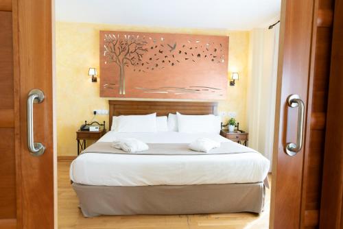 a bedroom with a large bed with two towels on it at Hotel Comendador in Carranque