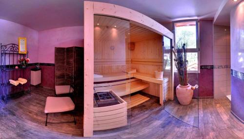 duży pokój z wanną i krzesłem w obiekcie Logis Hotel-Restaurant Spa Le Lac w mieście Embrun
