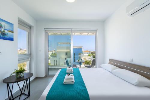 een witte slaapkamer met een groot bed en grote ramen bij Protaras Lifestyle Villa Mylos 9 in Protaras