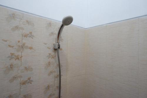 a shower with a microphone on the wall at RedDoorz Syariah near Stasiun Tegal in Tegal
