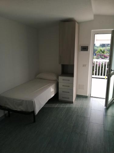 a bedroom with a bed and a door to a balcony at Campeggio Lao in Scalea