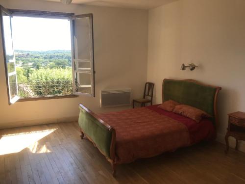 a bedroom with a bed and a large window at Librairie Abelard in Montolieu