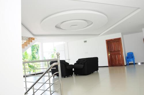 a room with a white ceiling with a table and chairs at Sunstar Nilaveli in Trincomalee