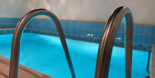 una piscina con tres barras de metal alrededor en Arees Beach, en Rayyis