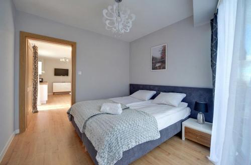 a bedroom with a large bed and a chandelier at Apartamenty EverySky - Wilcza 3F-1 in Karpacz