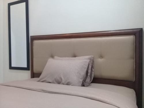 un letto con un cuscino bianco e uno specchio di Homestay Lovebird a Wonosobo