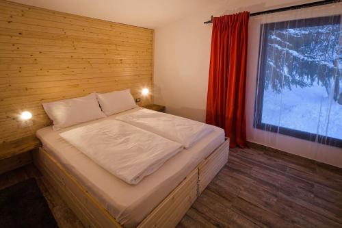 Dormitorio pequeño con cama y ventana en Vila Mura, en Topliţa