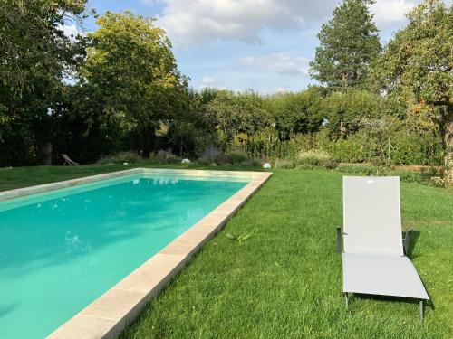 - une piscine dans une cour avec une chaise à côté dans l'établissement Le Gite du Chemin Vert, à Pontlevoy