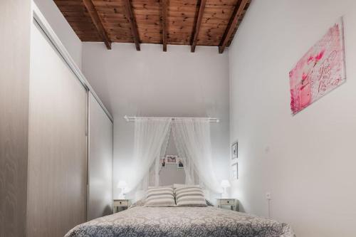 1 dormitorio con cama y techo de madera en Carlo Vivari House, en Vivari
