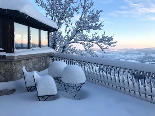 a balcony covered in snow with chairs and a window at Burg Plankenstein in Texing