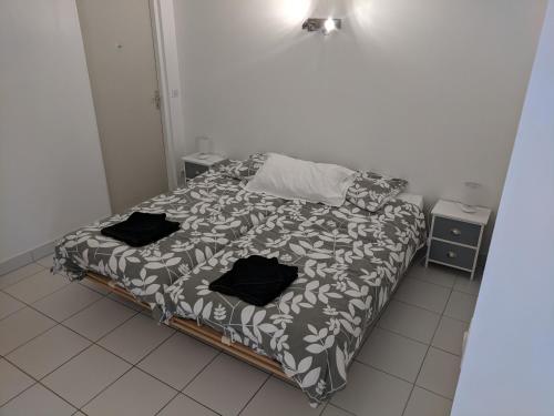 una cama con almohadas negras en una habitación en 2 person Apartment Ascain, en Ascain