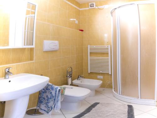 ein Bad mit einem Waschbecken, einem WC und einer Dusche in der Unterkunft Villa Gabriella in Porto Pino