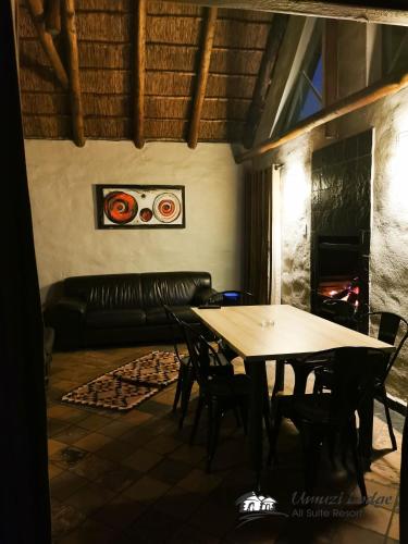 a table and chairs in a living room with a couch at Umuzi Lodge in Secunda