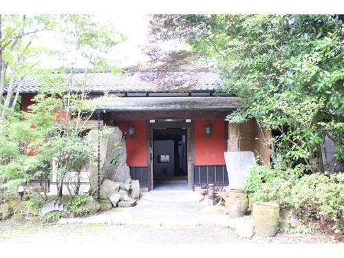 a small red building with a pathway leading to it at Kotohira Guest House en in Hita