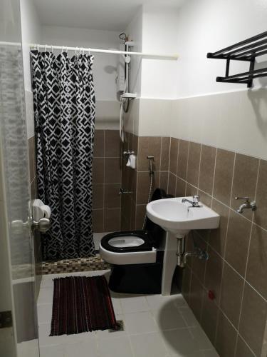 a bathroom with a toilet and a sink at Burnham Hill Condominium by KF in Baguio