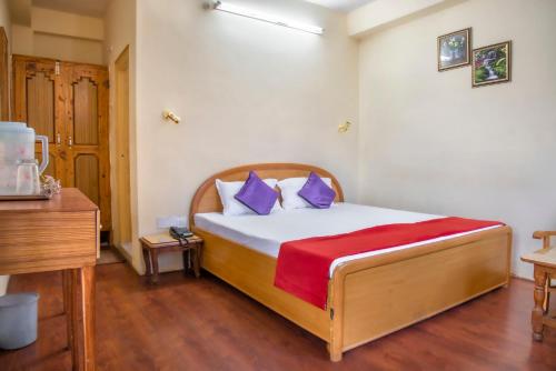 a bedroom with a bed with purple and white pillows at The Wild Trails by Livingstone in Kalpa