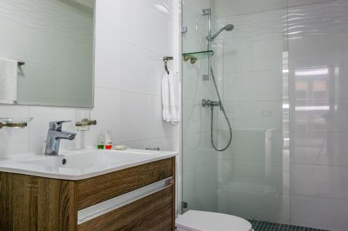 a bathroom with a shower and a sink and a toilet at Delightful Apartment City Center - PH Quartier Atlapa in Panama City