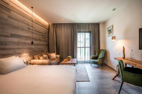 a hotel room with a bed and a couch at Kedem Hotel - Adults Only in Tirat Karmel