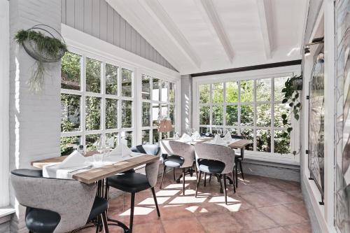a dining room with tables and chairs and windows at Appartementen De Torenhoeve in Burgh Haamstede