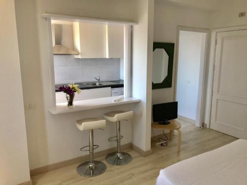 una pequeña cocina con 2 taburetes y lavamanos en Apartamentos Bruja, en Santa Cruz de Tenerife