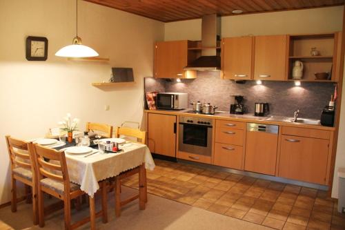 a kitchen with a table and chairs and a kitchen with at Nationalpark-Gastgeber Eifel in Blankenheim