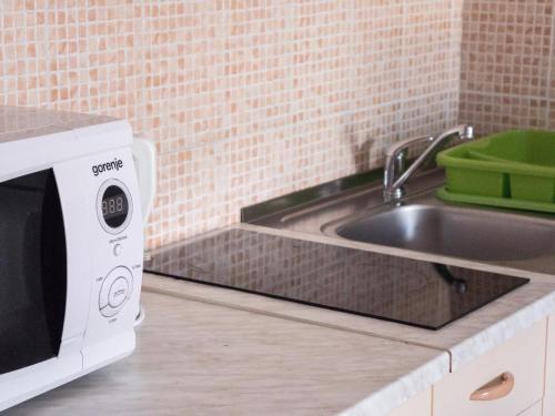 a kitchen with a sink and a microwave at Apartments Boki in Pag