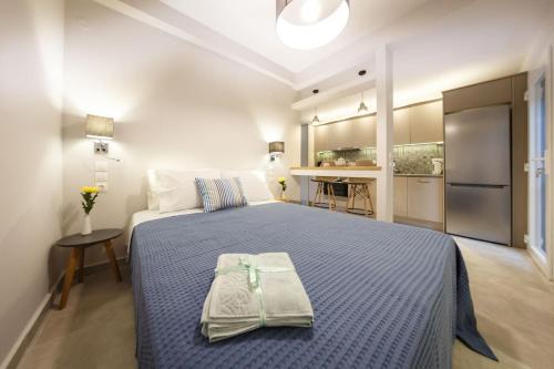 a bedroom with a large bed and a kitchen at Plession Apartment in Zakynthos Town