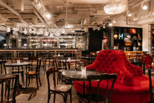 un ristorante con tavoli e sedie e un divano rosso di Ruby Lissi Hotel Vienna a Vienna