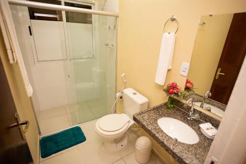 a bathroom with a toilet and a sink and a shower at Pousada o Caribe de Maragogi in Maragogi