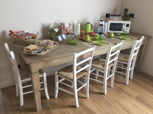 a kitchen table with four chairs and a microwave at B&B CORTE SANT'ANGELO in Passirano