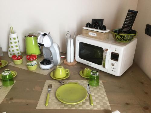 eine Mikrowelle auf einer Küchentheke mit grünen Tellern in der Unterkunft B&B CORTE SANT'ANGELO in Passirano