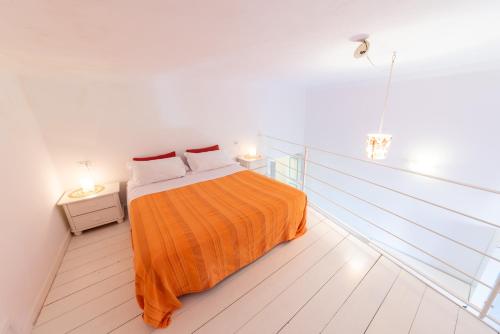 sypialnia z łóżkiem z pomarańczowym kocem w obiekcie A Casa di Mario w mieście Ischia