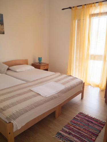 a bedroom with a bed and a window and a rug at Apartments Boki in Pag
