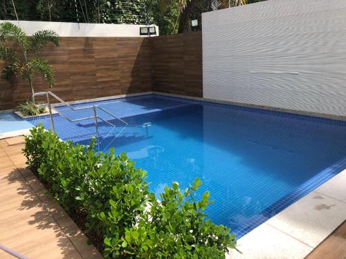 uma grande piscina azul com uma cerca de madeira em Veranno Di Porto-50mts Piscinas Naturais em Porto de Galinhas