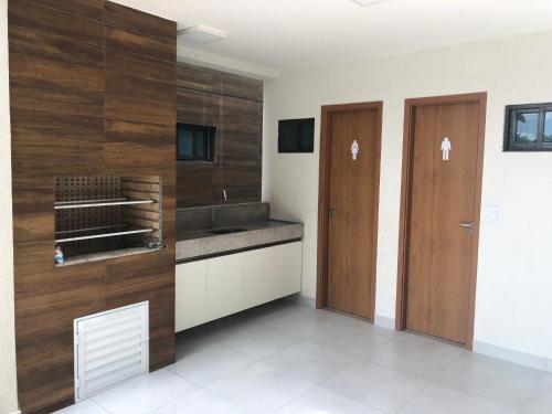 uma cozinha com paredes de madeira e duas portas de madeira em Veranno Di Porto-50mts Piscinas Naturais em Porto de Galinhas