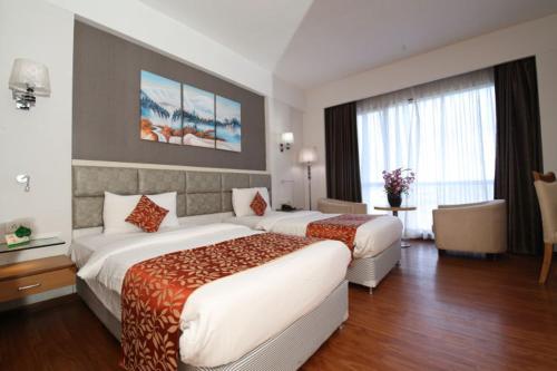 Cette chambre comprend deux lits et un bureau. dans l'établissement Maha Bodhi Hotel.Resort.Convention Centre, à Bodh Gaya