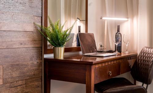 a desk with a laptop and a plant on it at Satori Hotel in Haifa