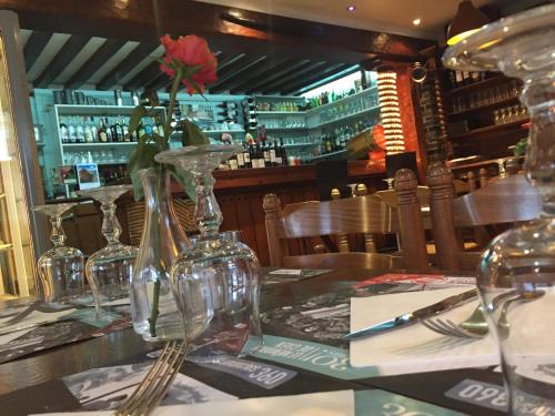 a table in a restaurant with wine glasses on it at Hotellerie Normande in Dozulé