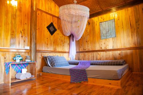 Sapa Orange Homestay في سابا: غرفة نوم بسرير في غرفة خشبية