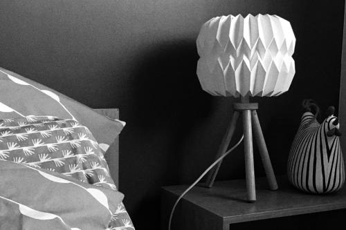 a lamp sitting on a table next to a bed at Disneyland cosy Apartment in Montévrain