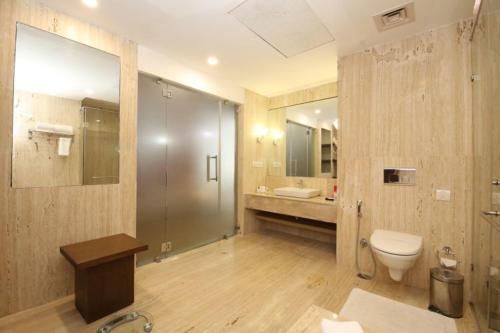 uma casa de banho com um chuveiro, um WC e um lavatório. em Maha Bodhi Hotel.Resort.Convention Centre em Bodh Gaya