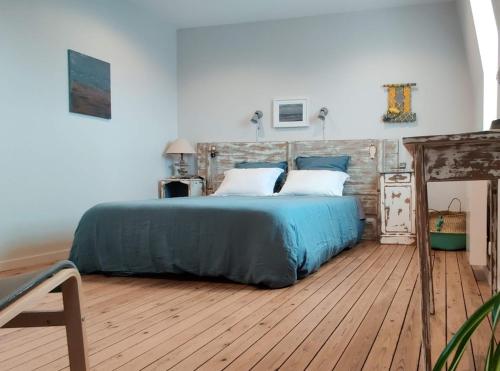 - une chambre avec un grand lit doté de draps bleus et d'oreillers blancs dans l'établissement Studio 