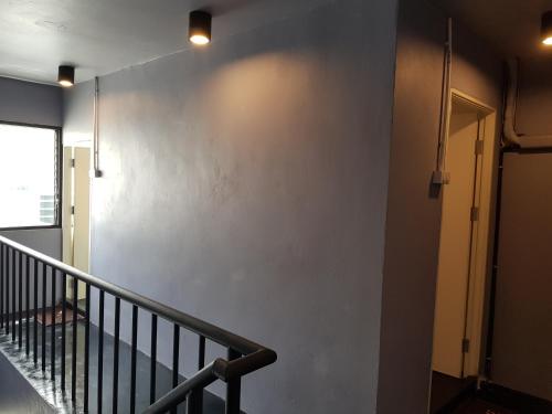 an empty hallway with a staircase and a wall at SleepCatsHostel in Bangkok