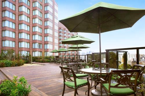 an outdoor patio with tables and chairs and umbrellas at Hotel Chinzanso Tokyo in Tokyo