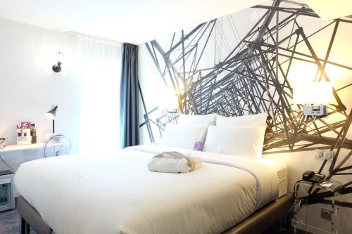 Schlafzimmer mit einem weißen Bett und einem großen Fenster in der Unterkunft Mercure Paris Malakoff Parc des Expositions in Malakoff