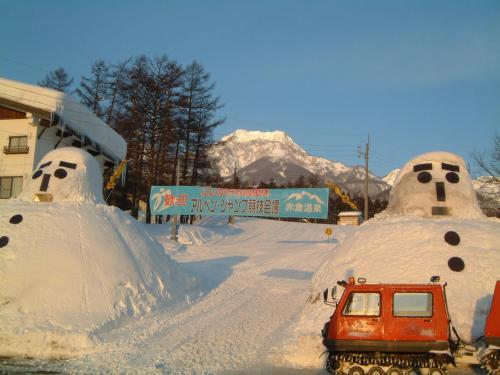 a car parked in front of snow covered buildings at Akakura Wakui Hotel in Myoko