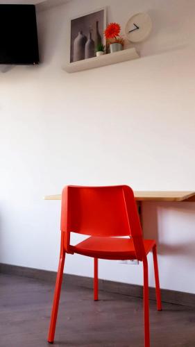 a red chair sitting in front of a desk at Pensión La Estrella in Zaragoza