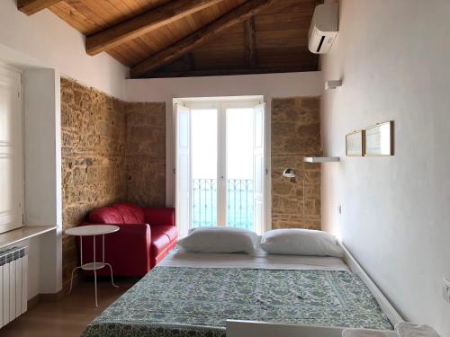 um quarto com uma cama grande e um sofá vermelho em Palazzo Pizzo Dependance delle Grazie em Pizzo