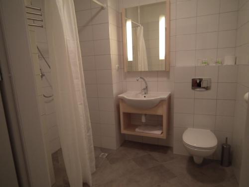 a bathroom with a sink and a toilet at 5A Hotel Services in Koszalin